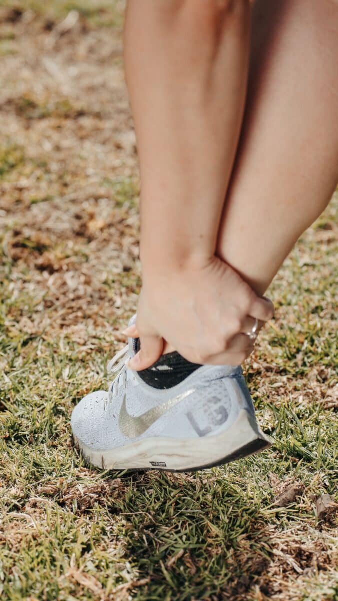 Person experiencing Achilles tendon pain at the back of the ankle